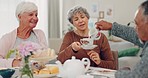 Senior man, women and pouring milk at tea party, helping hand and conversation with care, drink and retirement. Elderly group, chat and relax with reunion, coffee or brunch with social in living room