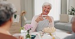 Tea, funny and elderly woman with friends in home living room, bonding and talking at table. Happy people, senior person and laughing at comedy, story and smile for conversation, gossip and coffee