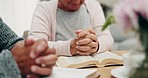 Closeup, senior couple and hands for praying, bible and faith in home with praise, worship and gratitude. Old people, holy books and peace with mindfulness, spiritual growth and together in house