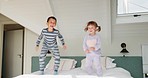 Girl, boy and children on bed, jump and playful with love, care and energy for funny game in family house. Young kids, bedroom and wake up with excited face, smile and together for bonding in home