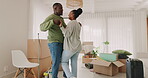 Dancing, happy couple and celebrate moving house with boxes in a room. New home, fun energy and love of excited black man and woman at property with commitment, care or support for homeowner mortgage