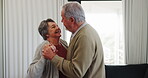 Dance, smile and a senior couple in their home for playful romance together during retirement. Smile, love or funny with a happy elderly man and carefree woman moving to music in the living room