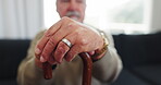 Cane, support and thinking with hands of old man on sofa for retirement, medical and relax. Healthcare, arthritis and walking stick with closeup of senior person in nursing home for osteoporosis