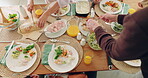 Above, table and family with food in home for meal, gathering of celebration of event with cooking, eating and healthy dinner. Lunch, meat and hands sharing or serving chicken on plate in dining room