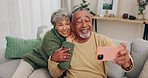 Senior couple, sofa and selfie with smile, hug or relax with web blog, post and love for bonding in home living room. Old man, elderly woman and happy for memory, social media or photography in house