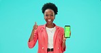 Thumbs up, phone and black woman with green screen in studio isolated on a blue background. Mobile, mockup space or presentation for promotion, advertising or excited for tracking markers in portrait