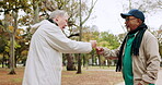 Senior men, fist bump and forest hiking, park fitness and retirement support, teamwork and health in winter. Happy elderly people or friends with handshake for exercise or cardio wellness in nature