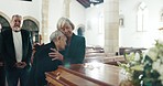 Senior women, hug and funeral in church for comfort, support and care with crying, sad and religion. Family, friends and embrace for death, loss and console with love, empathy and faith by coffin