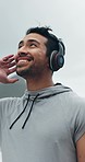 Exercise, music and smile with a sports man turning around, looking at the view in a harbor during his workout. Fitness, thinking and inspiration with a happy young male athlete training outdoor