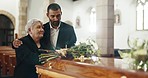 Funeral, church and elderly mother and man mourning death by coffin with flowers. Grief, family and son with mom by casket to comfort, support or interracial empathy for depressed or sad senior woman