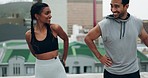 Young couple, fitness and training on rooftop with stretching, talk and smile with motivation, support and outdoor. Man, woman and workout together for warm up, muscle and happy with teamwork in city