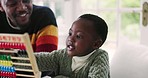 Black family, abacus and father with child for learning, education and mathematics lesson at home. School, academic and happy dad teaching boy at table for development, homework and educational toy