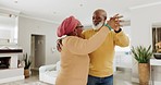 Senior African couple, dance and home in living room with romance, celebration and comic bonding. Elderly black woman, man and happy for dancing, moving and steps with love in lounge at apartment