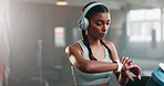 Woman, fitness and running on treadmill for exercise, workout or cardio training while checking watch at gym. Active, runner or sports female person and athlete looking at wristwatch for healthy body