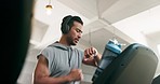 Fitness, exercise and man on a treadmill with headphones and watch at gym training for wellness. Profile of Asian person listening to music for running, cardio time or workout on machine for health