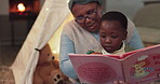 Home, grandmother and a child reading a book for learning language, education and development. African woman and kid at a fort with a story at night for bonding, family time and teaching with love