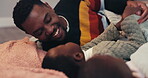 Black family, children and a father on the bed with his son for fun together while playing  happy game. Smile, love and funny with a young male parent and boy child in the bedroom of their home