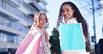 Happy woman, friends and walking with shopping bag in city together for discount, sale or outdoor purchase. Rear view of women or shopper smile in happiness, satisfaction or fashion in an urban town