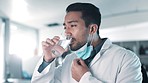 Thirsty scientist, man and face mask in a lab with water for hydration during research work. Healthcare, Asian employee and a drink in a biotechnology workplace for pharmaceutical development