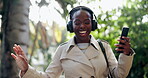 Black woman, phone and dancing in park to music in relax for fun audio or outdoor streaming. Happy African female person walking and listening to sound track, podcast or radio on headphones in nature