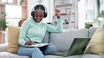 Black woman, laptop and listening to music while studying or writing in notebook on living room sofa at home. Happy African female person or student enjoying audio streaming in relax on computer