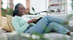 Music, writing and done with a student black woman on a sofa in the living room of her home to relax after study. Notebook, headphones and complete with a young pupil in her house to finish homework