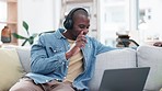 Happy, sofa and black man with music and a laptop with headphones for audio, podcast or radio. Smile, home and an African person on the living room couch streaming or listening to a playlist on a pc