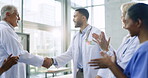 Happy, applause or doctors shaking hands for success, good job or bonus promotion in a hospital meeting. Group clapping, congratulations or proud healthcare worker with handshake for medical teamwork