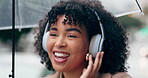 Black woman, headphones and dance to music in city, street or walking with radio, song or hear techno audio. Happy, listening and person streaming hip hop, track or podcast in the rain with umbrella