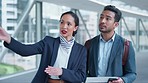 Woman, man and point with ticket for airport concierge, direction and compliance check in lobby. Confused entrepreneur, airline service employee and show documents for identity, travel and inspection