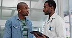 Healthcare, tablet and black man consulting doctor in a hospital for results, diagnosis or planning treatment. Health, advice and African male patient with specialist online checking surgery schedule