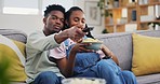 Happy, relax and a black couple with chips while watching tv, comedy show or film on the sofa. Smile, laughing and an African man and woman with food, streaming movie and together in a house