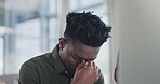 Stress, tired and man with a headache in the office on a computer working on a project. Exhausted, burnout and overworked young African male designer with a migraine on a desktop in the workplace.