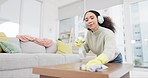 Cleaning, headphones and woman with spray and cloth for dust, bacteria and dirt on furniture. Maid service, housekeeping and person listening to music, radio and audio for housework with disinfectant