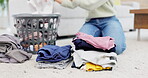 Hands, fold laundry and person with  pile of clean clothes in house on living room floor or housekeeper in spring cleaning. Washing, basket and order clothing by color or woman work in home service
