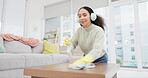 Headphone, music and woman spray cleaning on a table in home living room as for hygiene, protection or disinfection. Dirt, dust and person or cleaner doing domestic or sanitary housekeeping work