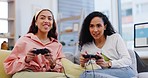 Lesbian couple on sofa playing video games, fun and relax in living room of home together on internet, controller and streaming. Online gaming, esports and lgbt gamer women on couch with virtual app.