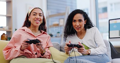 Lesbian couple on sofa playing video games, fun and relax in living