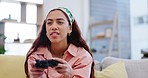 Woman on sofa playing video games, concentrate and relax in living room of home with internet, controller and streaming. Online gaming, esports and young gamer girl on couch with virtual subscription