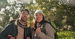 Nature, exploring and couple hiking in a forest for an adventure or journey while on a weekend trip. Conversation, woods and young man and woman outdoor trekking together with backpacks on vacation.