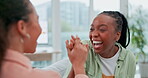 Smile, high five and woman friends laughing while talking in the living room of an apartment together. Support, motivation and funny humor with young people in a home for happy bonding or joking