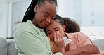 Crying, empathy and woman hugging her friend for breakup, divorce or failure in the living room. Depression, mental health and African female people with comfort for sad emotion in modern apartment.