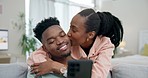Couple, kiss and phone on home sofa while streaming, online shopping and happy in a lounge. Black man and woman hug on a couch with love and a smartphone for internet, social media and mobile app