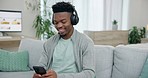 Happy black man, smartphone and headphones on sofa for streaming sound, radio app and audio subscription. Guy with cellphone listening to music, search podcast and digital multimedia in living room 