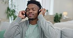 Happy black man, headphones and dance on sofa for sound, radio and audio subscription. Young guy dancing with freedom while listening to calm music, podcast media and hearing jazz song in living room