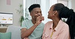 Black couple on sofa with popcorn, romance and smile on date together in living room of home. Relax, African man and happy woman eating snacks on couch with playful love, bonding and fun in apartment