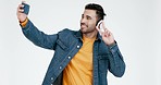 Man, selfie and happy in studio, peace sign and kiss with funny face, icon and comic by white background. Gen z influencer guy, photography and memory with vote, headphones and post on social media