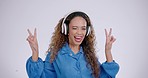 Woman, funny face and peace sign with music in studio with a smile with v hand gesture. Grey background, comic and female person with portrait and excited with headphones and happy emoji hands