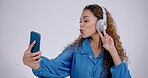 Happy woman, peace or headphones for selfie in studio for video call, vlog and social media post on white background. Profile picture, gen z model and v sign with tongue out, kiss emoji and broadcast