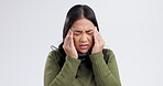 Woman, headache and pain for stress, mental health or crisis and risk or massage temple on a white background. Young asian person with migraine, tired and stress or confused and frustrated in studio